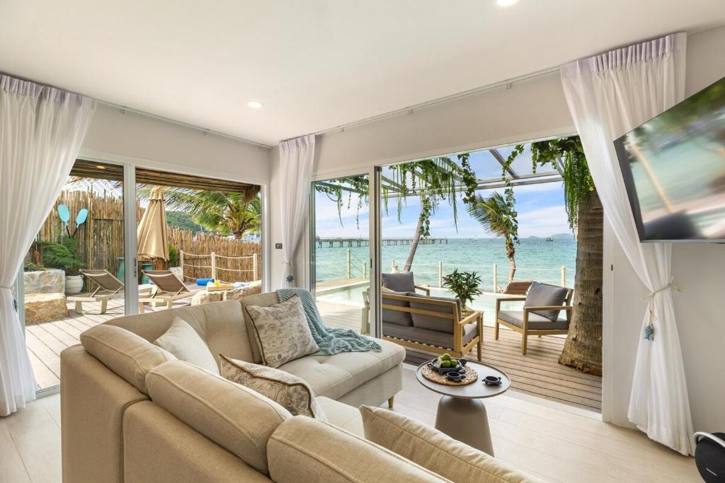 a living room with a couch and a view of the ocean at Little Me Beachfront Villa in Nathon Bay