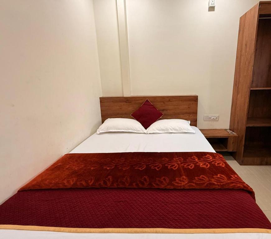 ein Schlafzimmer mit einem großen Bett mit einer roten Decke in der Unterkunft Port Inn Lodge in Mangaluru