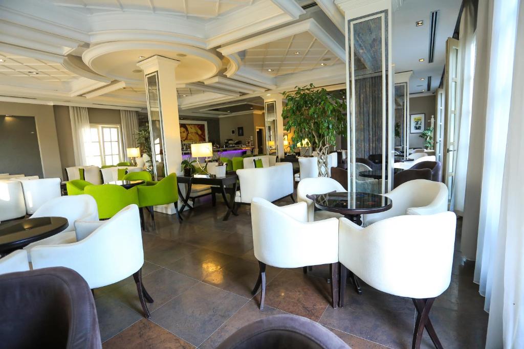 a dining room with white chairs and a table at Hotel Monarch in Elbasan