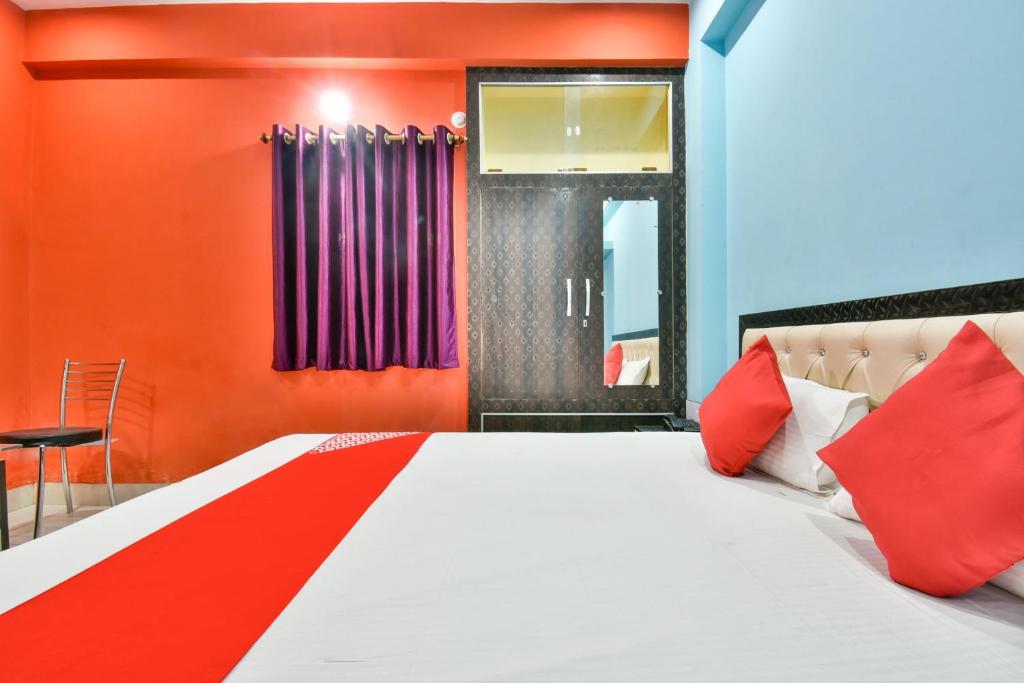 Hotel O Magadh Imperial في Patna: غرفة نوم بسرير بجدران حمراء وزرقاء