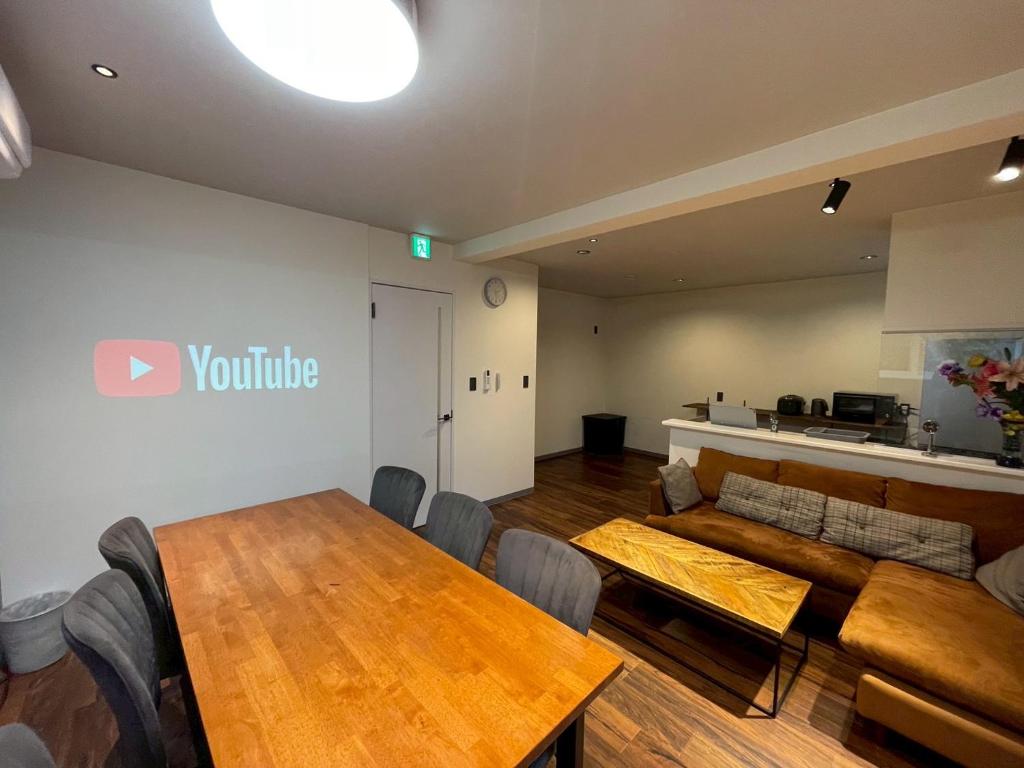 een woonkamer met een tafel en een bank bij KUSUO HOUSE Roji in Sapporo