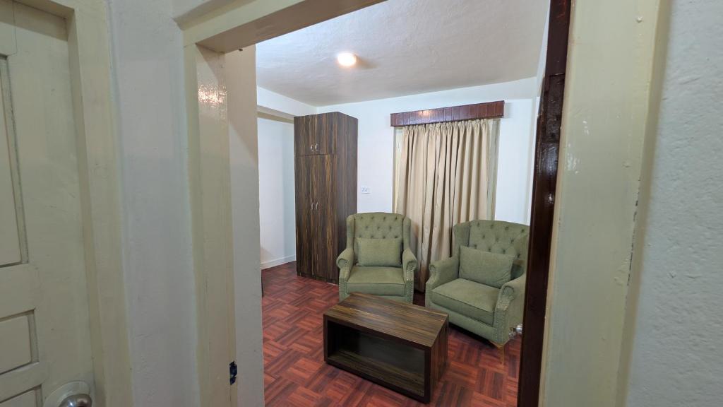a corridor with two chairs and a table in a room at TUYU Chhye in Kathmandu