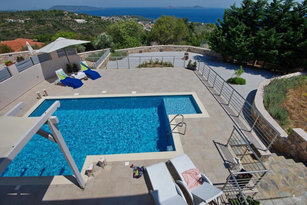 an overhead view of a swimming pool with chairs around it at Villa Eos - Luxury Private Pool Villa with Panoramic Sea Views in Alonnisos