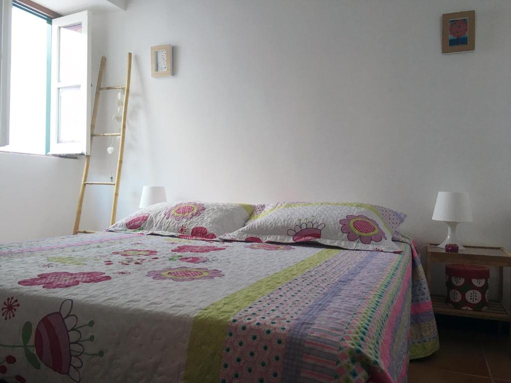 ヴィラ・レアル・デ・サント・アントニオにあるCasa da Princesaのベッドルーム(キルト付きのベッド付)