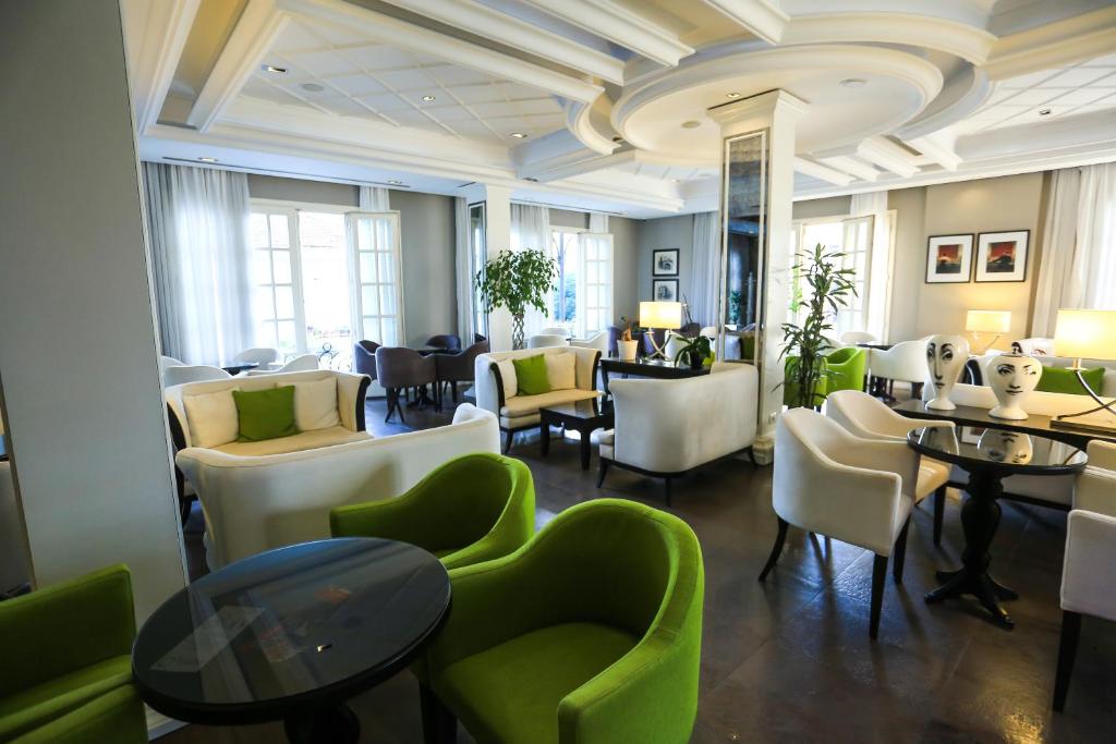a restaurant with green chairs and tables and chairs at Hotel Monarch in Elbasan
