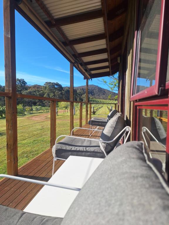 een veranda met ligstoelen en uitzicht op een veld bij Milpa's Cottage Tandamuki in Moonambel
