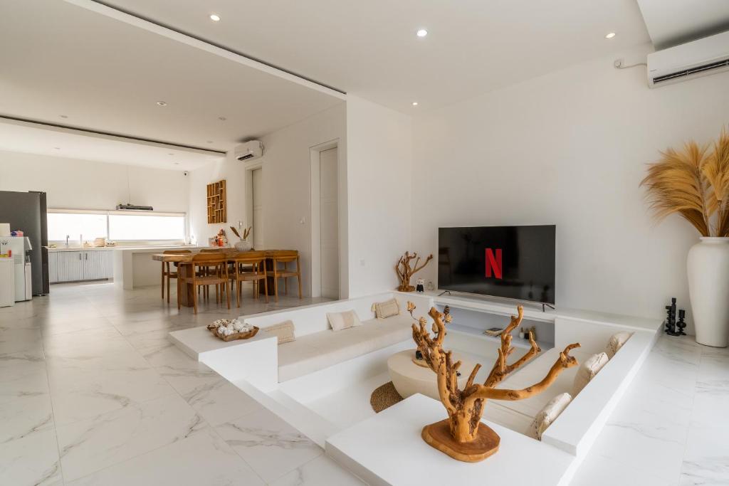 a living room with white walls and a fireplace at Villa Buho Ungasan - Luxury Villa 4br in Ungasan