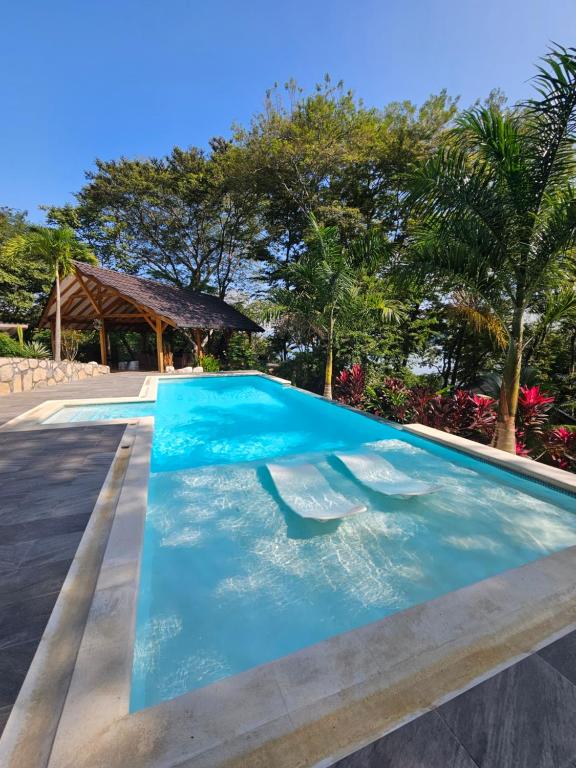 a swimming pool in a resort with trees in the background at Beach resort playa Leona in Gigantes