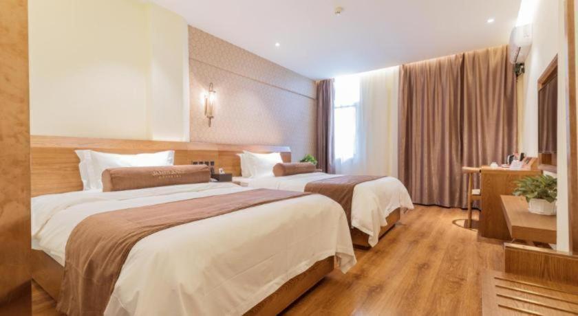 a hotel room with two beds and a window at James Joyce Coffetel Qufu Tourist Center Gulou Street Sankong Scenic Spot in Qufu