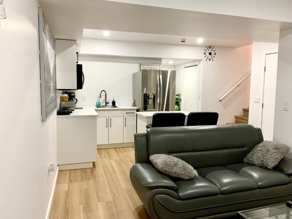 a living room with a couch and a kitchen at Royal Oak in Winnipeg