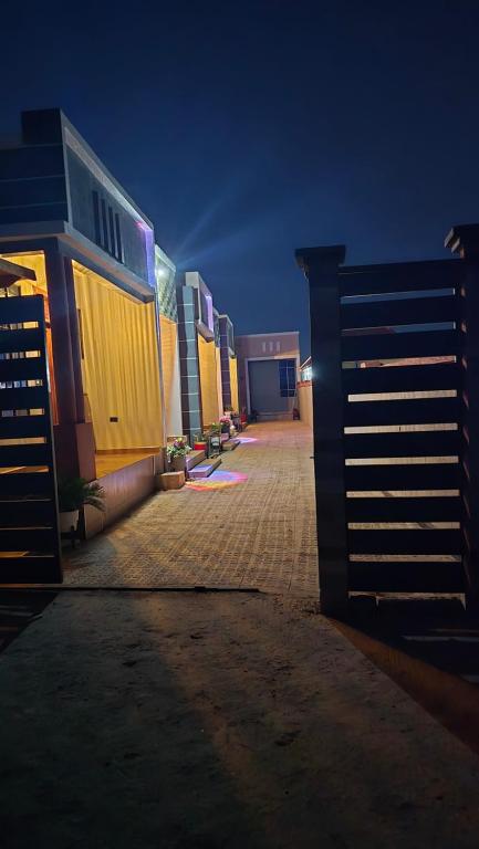 an empty street with a fence and buildings at night at Royal Katavi Villa 