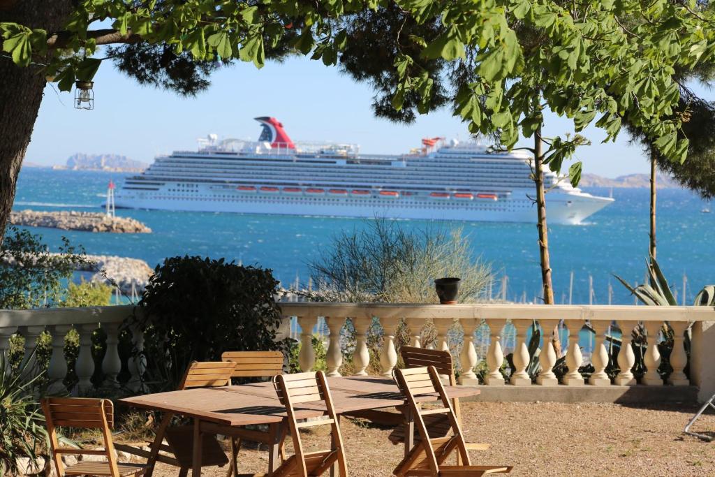 a cruise ship in the water with a table and chairs at Maison d'Hôtes La Bastide Bleue in Marseille