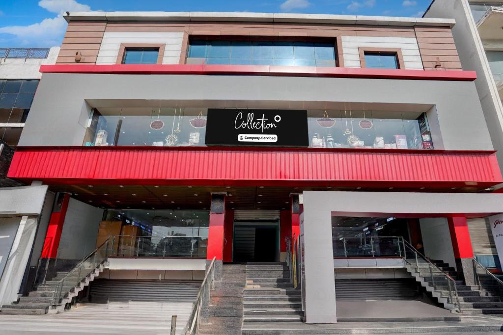 Un edificio con un toldo rojo y escaleras en el frente. en Collection O High Court Lucknow, en Vibhuti Khand