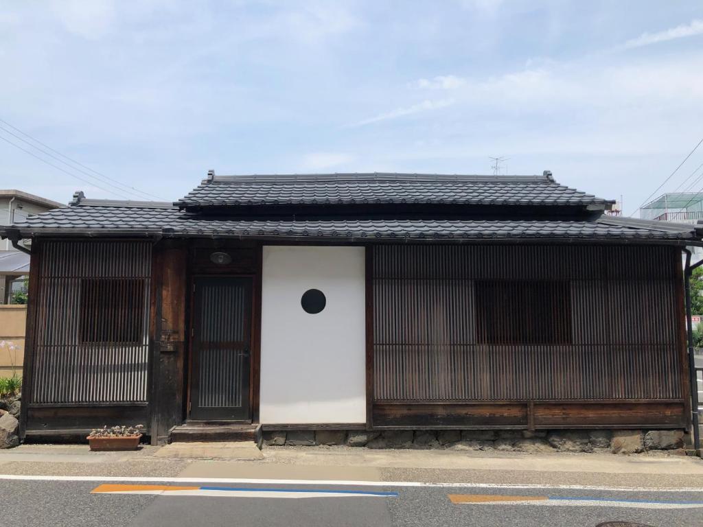 a small building with a black roof on a street at Ichiban an in Uji