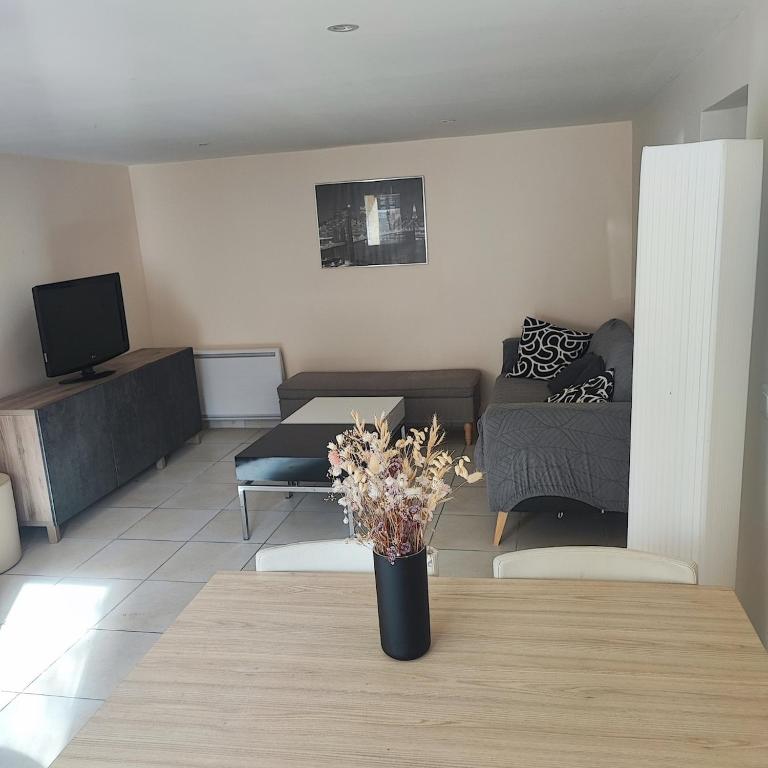 a living room with a vase of flowers on a table at Cozy house, small garden and parking, train station on foot in Orgerus