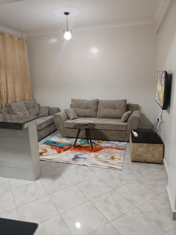 a living room with a couch and a table at 1 bedroom BNB Makutano Meru 06 in Meru