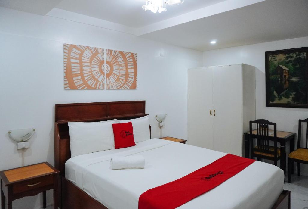 une chambre avec un lit blanc avec une couverture rouge dans l'établissement RedDoorz at La Casa Guesthouse former RedDoorz at Tamarind Street Angeles City, à Ángeles