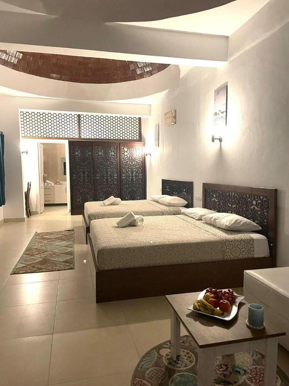 um quarto grande com duas camas e uma mesa em Sunshine Divers Shark's Bay em Sharm El Sheikk