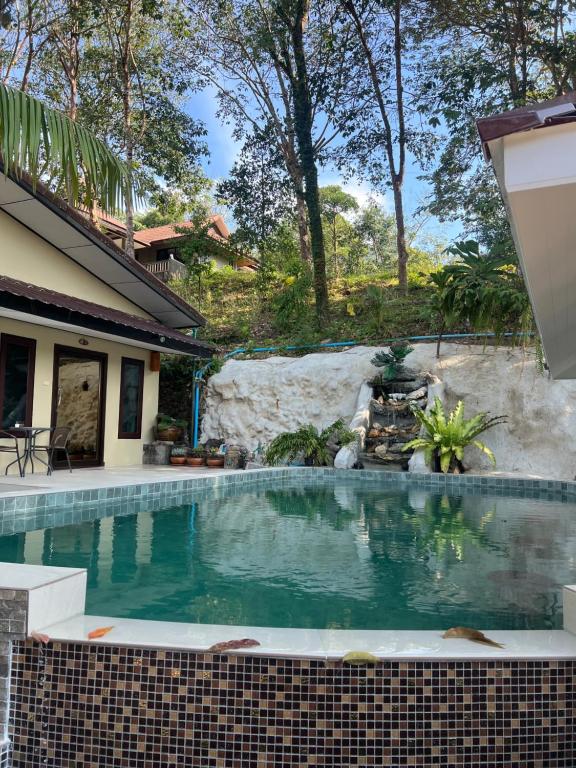 Baan Ton Rak Boutique Resort في كو تشانغ: حمام سباحة أمام منزل