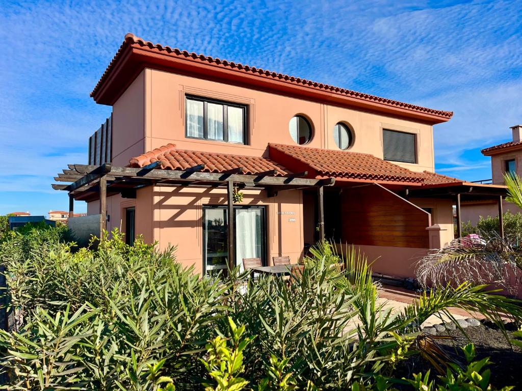 a pink house with a red roof at Villa Maracuya in Lajares