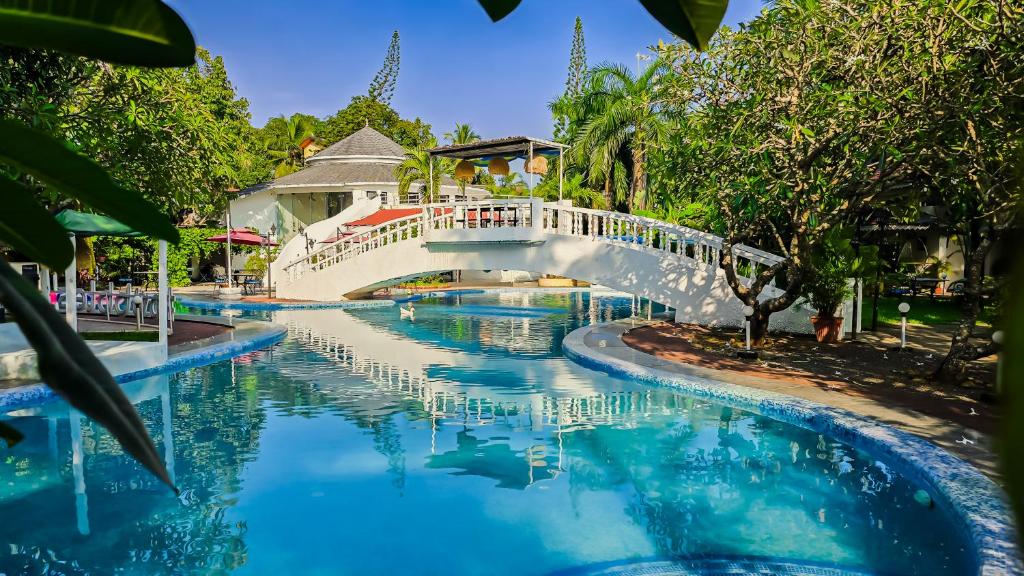 a bridge over a river in a resort at Sashas Holiday Village in Vagator
