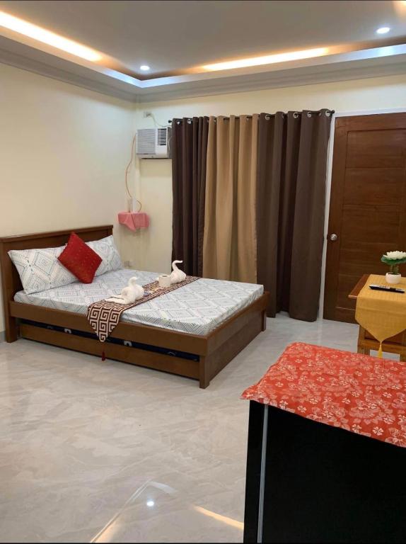 a bedroom with a bed in a room at Piccadilly Green Villas Apartment in Dauis
