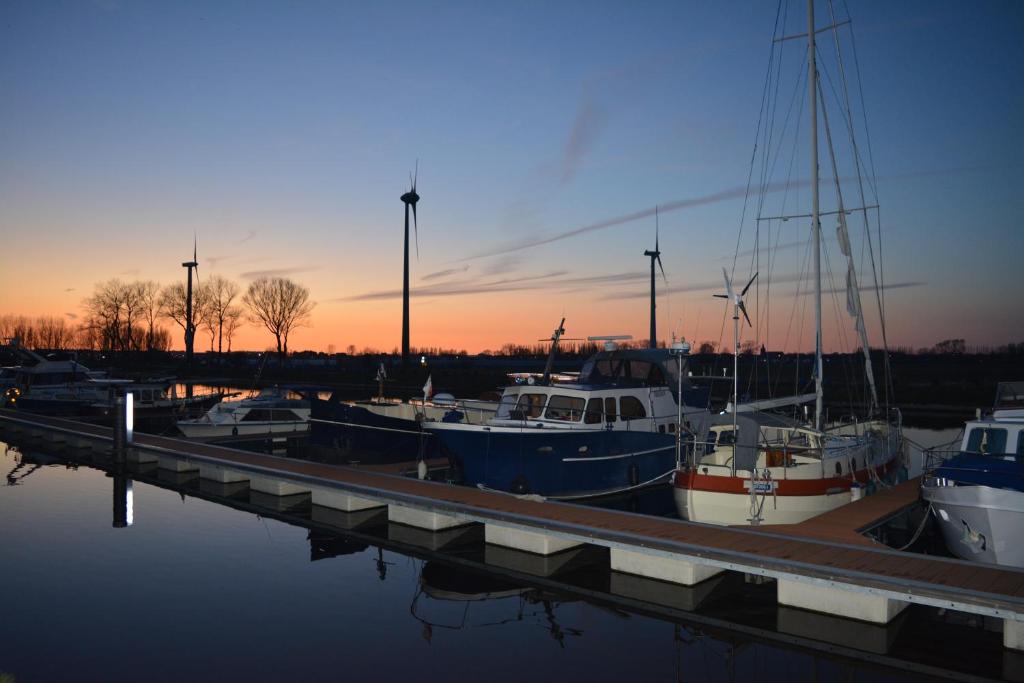 a group of boats docked in a marina at sunset at Holiday Home Nieuwendamme in Nieuwpoort