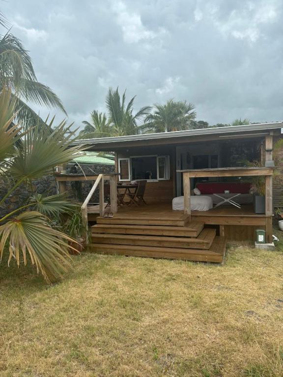 ein Haus mit einem Bett auf einer Holzterrasse in der Unterkunft Le petit refuge in Les Avirons