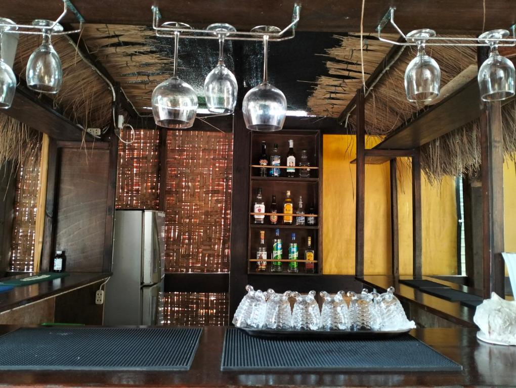 Eddie`s Beach Resort Siargao في جنرال لونا: بار مع مجموعة من الزجاجات على منضدة