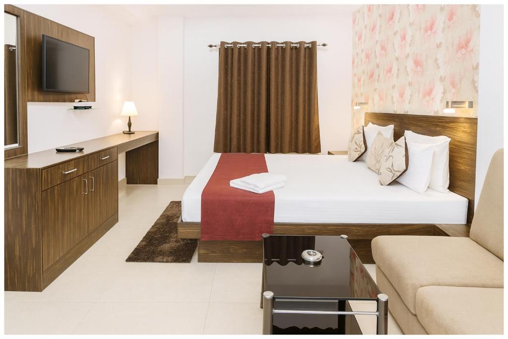 a hotel room with a bed and a couch at Kanha Classic Inn Near Lucknow Railway Station # Free Wifi # Room Service And Parking Facility - Fully Air conditioning Premium Room - Best Premium Hotel In Lucknow in Lucknow