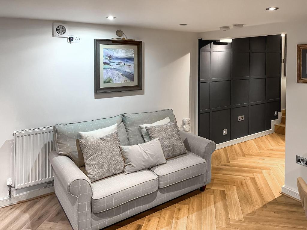 un divano grigio in un soggiorno con pavimenti in legno di Otter Hollow a Middleton