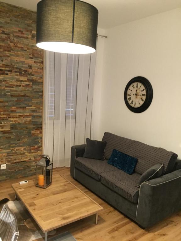 un salon avec un canapé et une horloge au mur dans l'établissement CANNES CROISETTE b, à Cannes