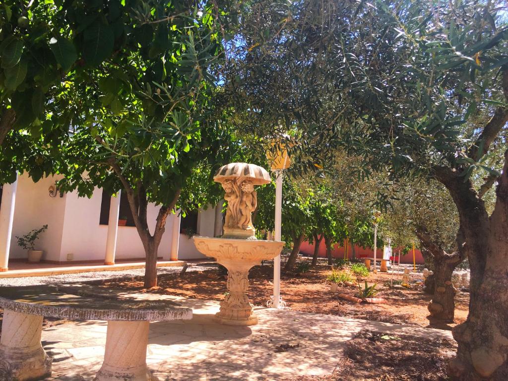 a fountain in the middle of a park with trees at Hotel Bon Lloc in Ulldecona