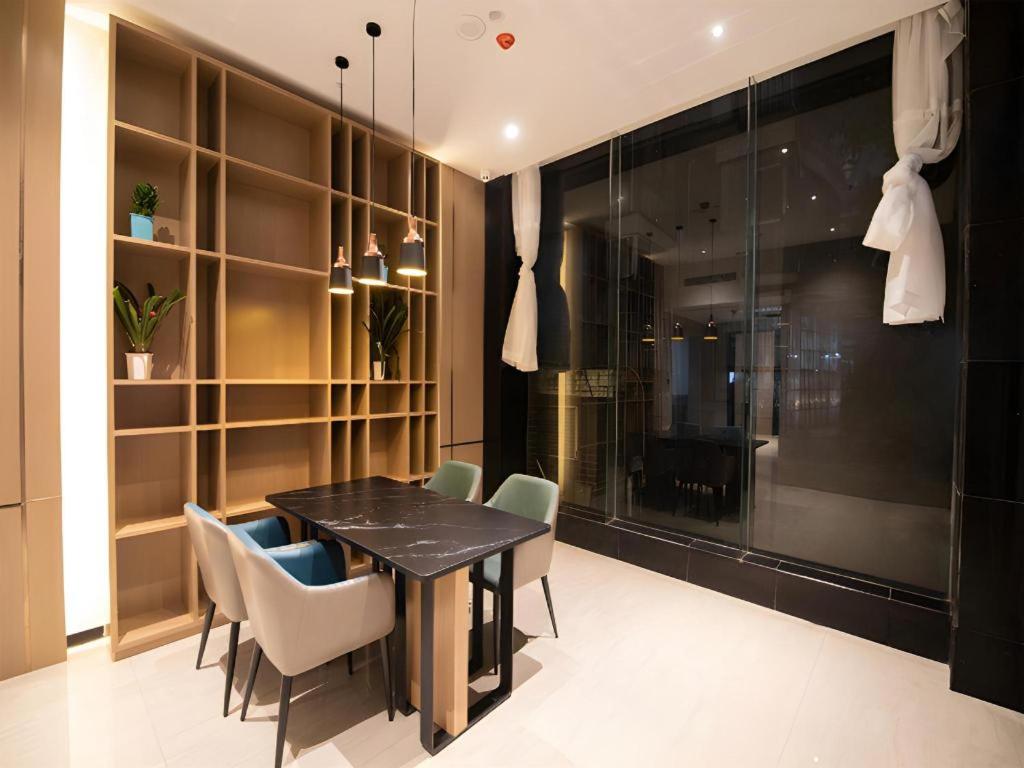 a dining room with a black table and chairs at City Comfort Inn Changsha Sifangping University of National Defense Science and Technology in Changsha
