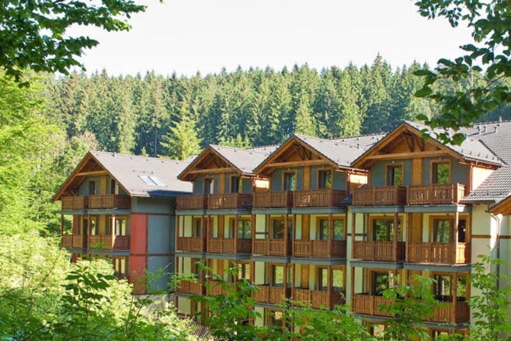 un gran edificio de apartamentos con balcones de madera y árboles en Fatrapark 2 Apartments HRABOVO - Hlavná recepcia, en Ružomberok