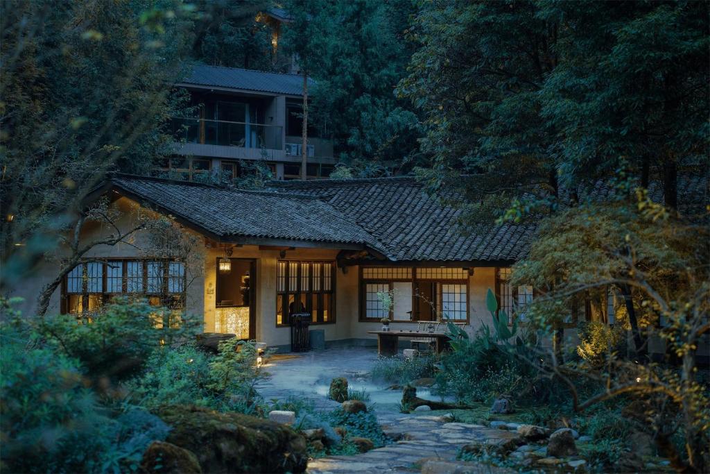 ein Haus mitten in einem Garten bei Nacht in der Unterkunft Relais & Châteaux Su Shien Valley Hotel in Dujiangyan