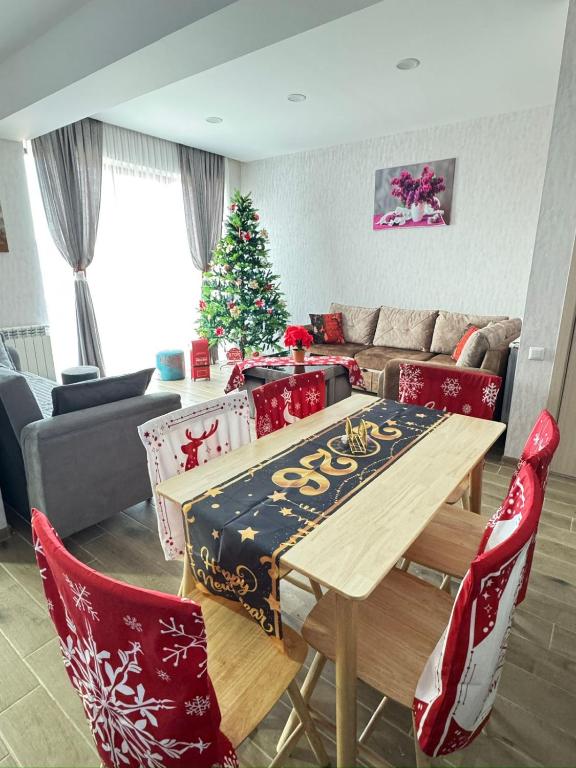 a living room with a table and a christmas tree at Eco Cottage BaBi in Bakuriani