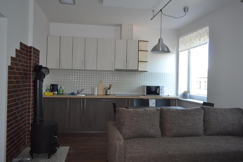 ein Wohnzimmer mit einem Sofa und einer Küche in der Unterkunft NG Apartments in Plungė
