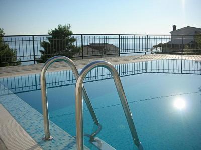a swimming pool with two metal hand rails in it at Mimice Bay Apartments in Mimice