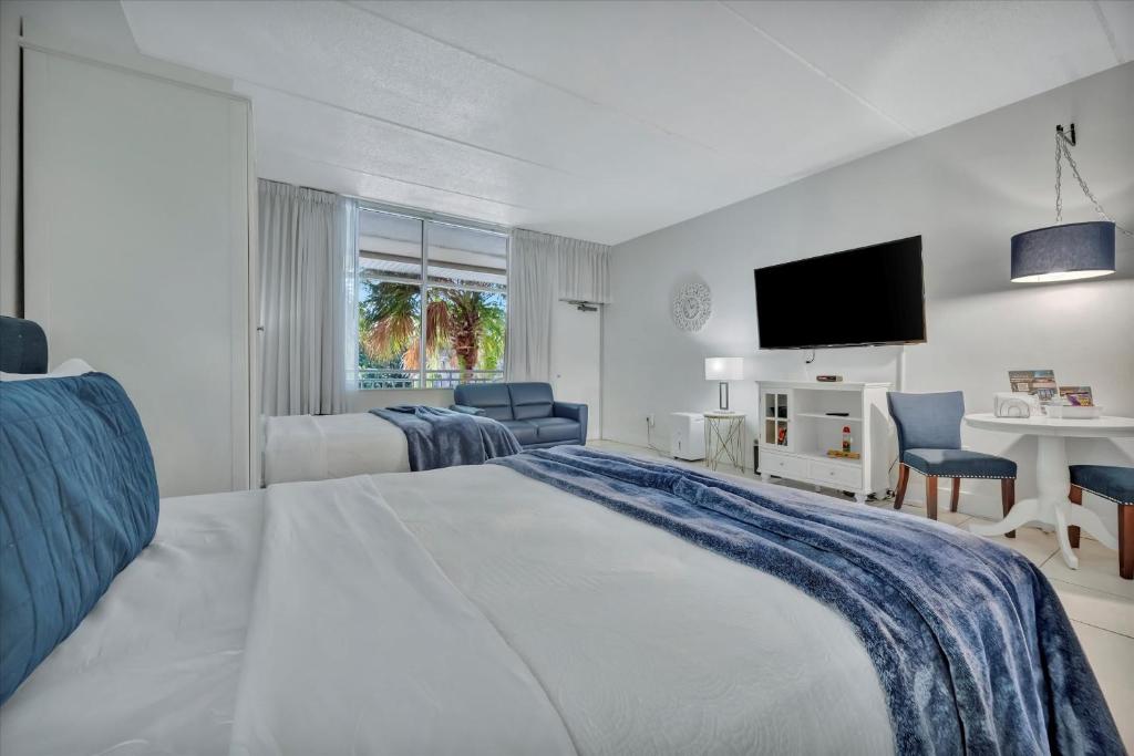 a hotel room with a large bed and a television at Sunset Suite - Private Balcony Gym & Pool in Ruskin