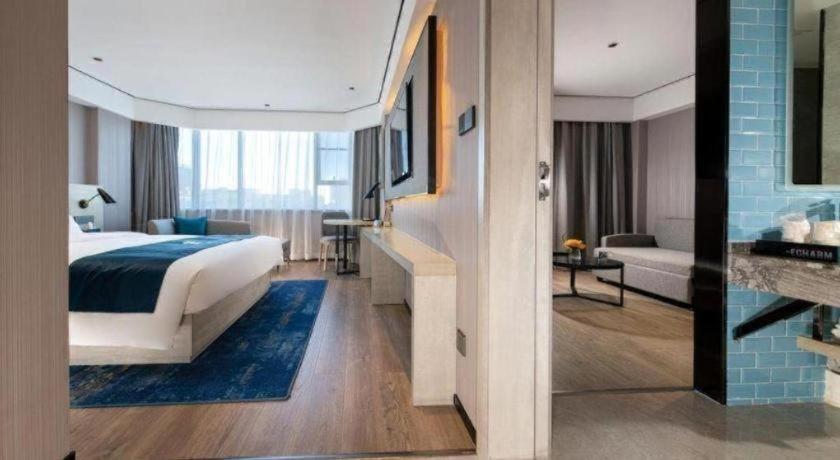 Una habitación de hotel con una cama y una sala de estar. en Echarm Hotel Shenzhen International Exhibition Center Fuyong, en Fenghuangwei