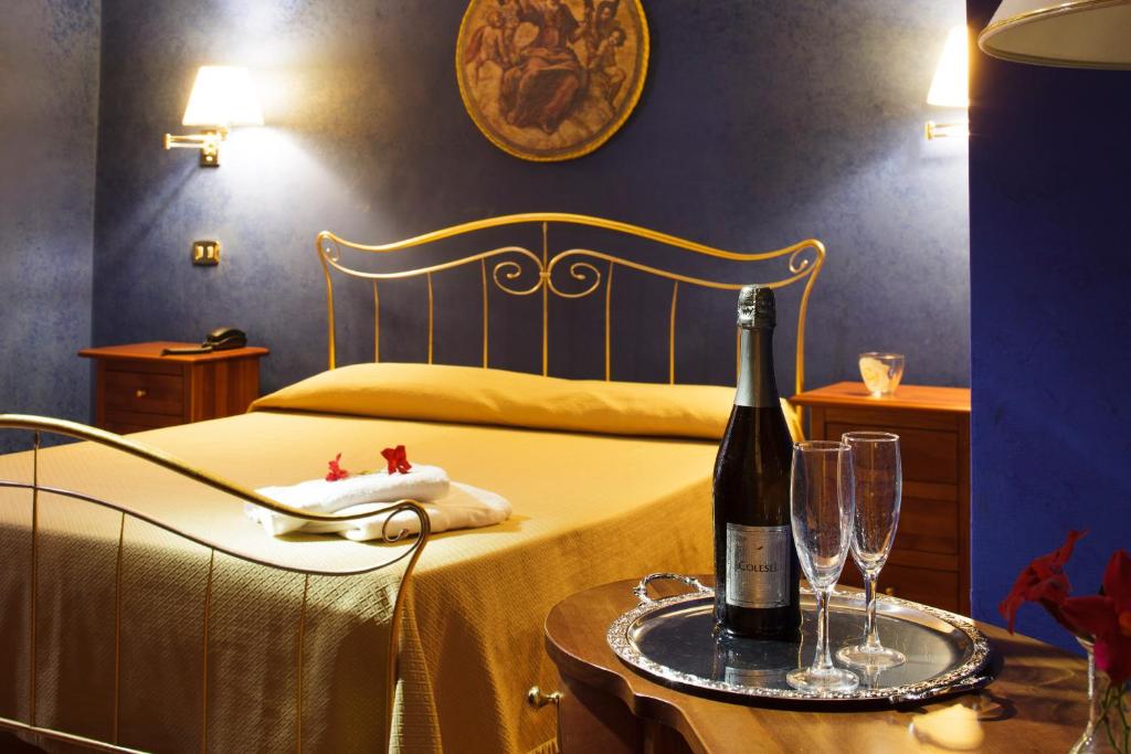 1 dormitorio con 1 cama y 1 botella de vino en la mesa en Hotel Relais Filonardi, en Veroli