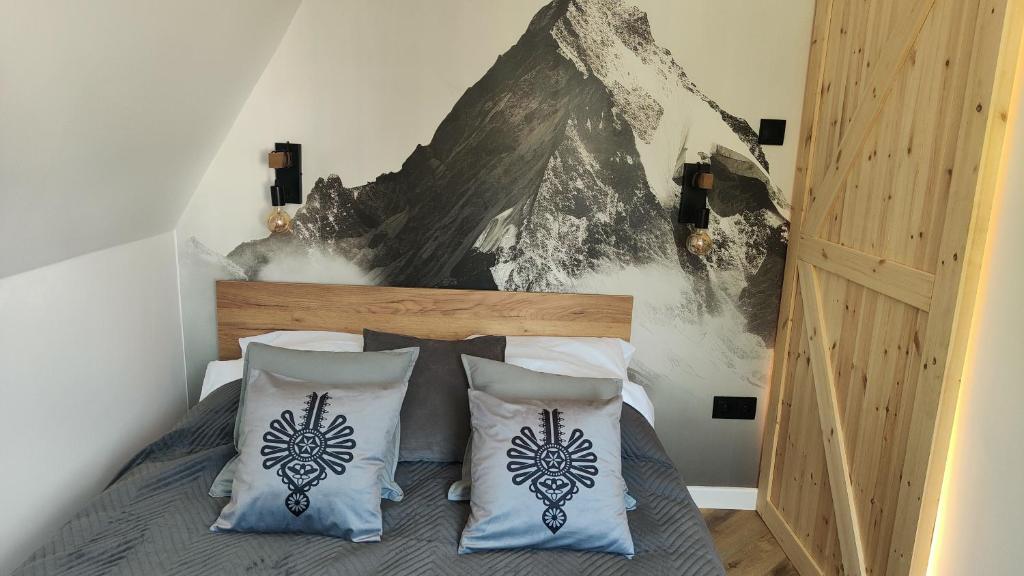 a bedroom with a bed with a mountain mural on the wall at Studio Góralskie Klimaty z widokiem na Góry, Kominek, Parking, Jacuzzi, Sauna in Biały Dunajec