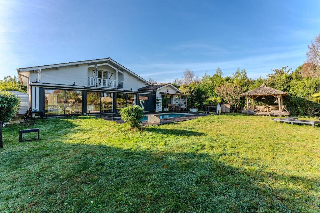 a home with a large yard with a house at Villa Saint Barth in Gujan-Mestras