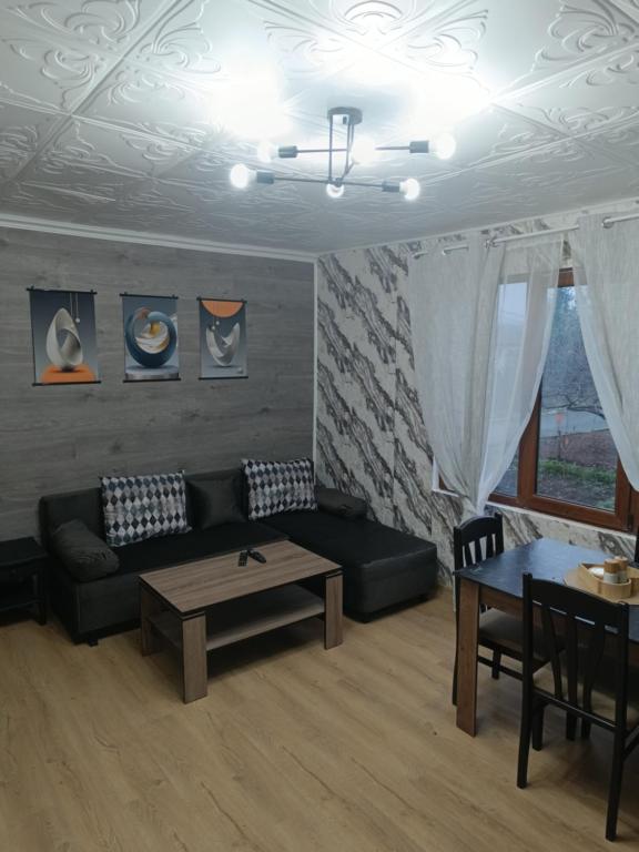 ein Wohnzimmer mit Sofa und Tisch in der Unterkunft Апартамент за гости Парадайс in Malko Tŭrnovo