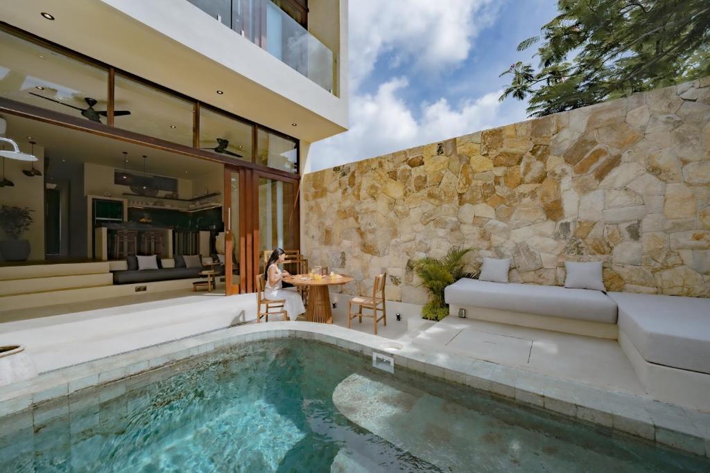 a home with a swimming pool and a house at Casa Beso Balangan in Badung