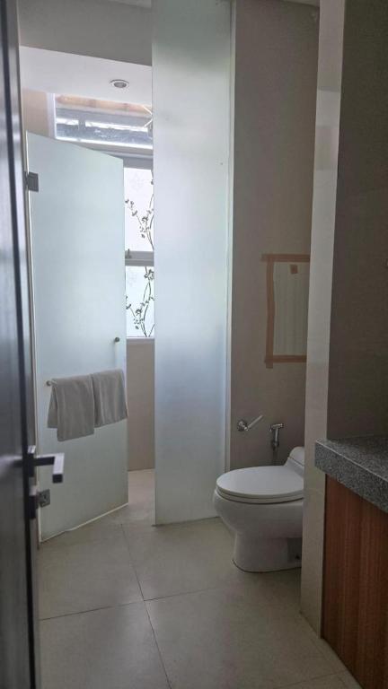 een badkamer met toilet en douche met handdoeken bij Villa Don Bose 8 in Jimbaran