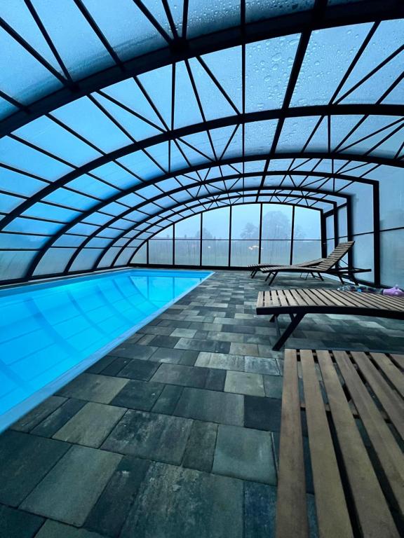 une piscine avec un banc dans un immeuble dans l'établissement Leśna Balia - Domek z balią na wyłączność, à Stogniewice