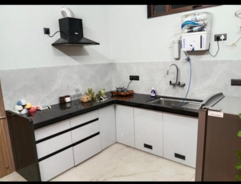 eine Küche mit weißen Schränken und einer Spüle in der Unterkunft Madhav villa in Jaipur
