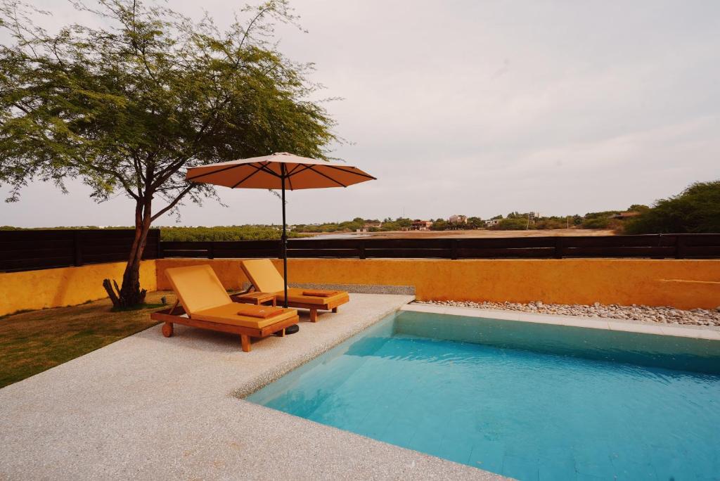 two chairs and an umbrella next to a swimming pool at Aerys Village in Somone